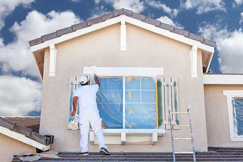 painter painting outdoor of a house